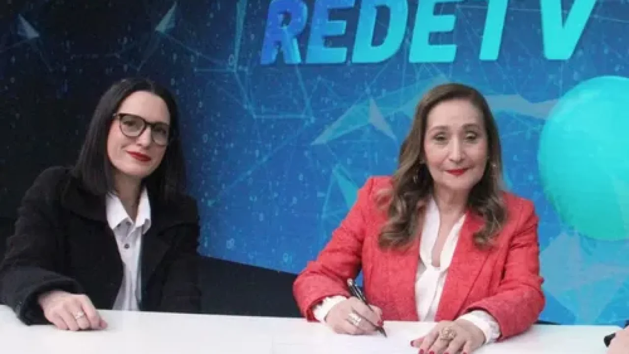 Sonia Abrão com um blazer colorido, sentada no estúdio da RedeTV!