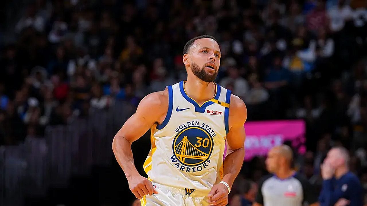 Jogador do Golden State Warriors corre em quadra durante partida da NBA com torcida ao fundo