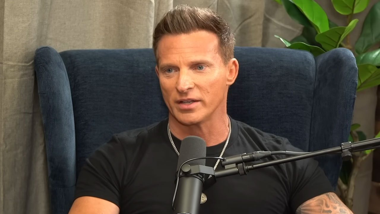 Ator Steve Burton sentado em poltrona azul fala ao microfone durante participação em podcast