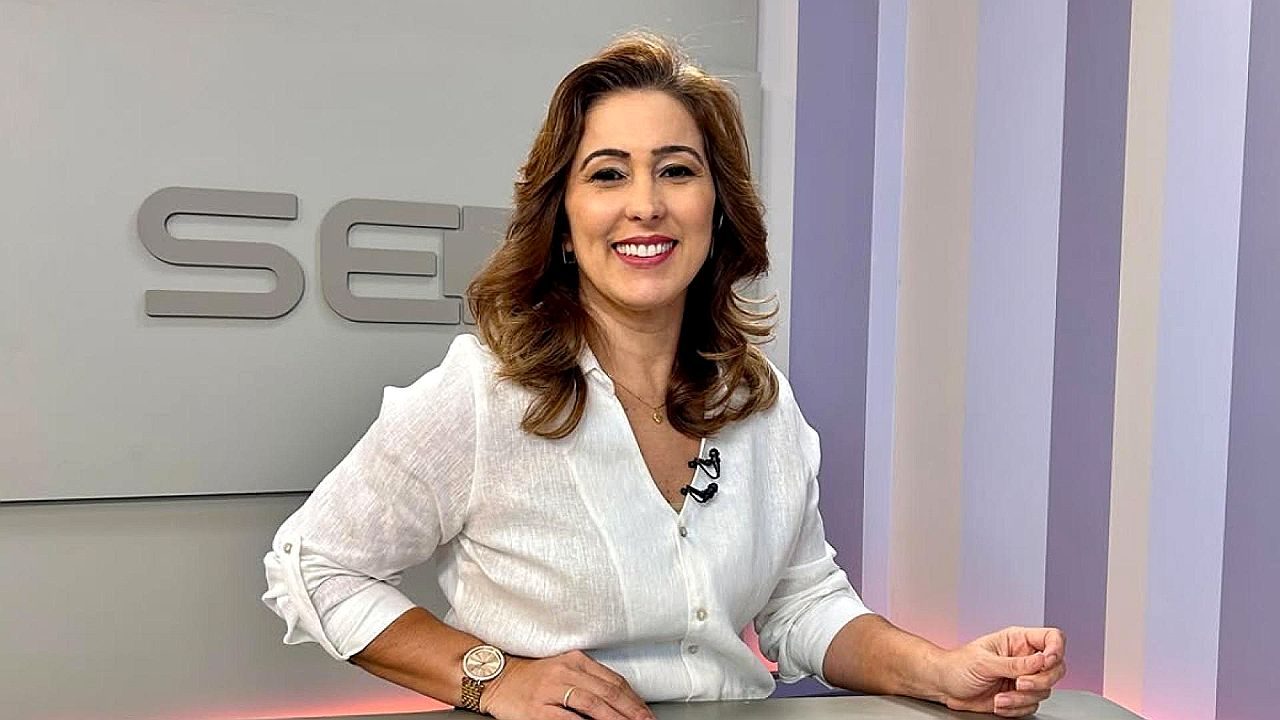 Susane Vidal sorrindo durante apresentação de telejornal no estúdio da Globo