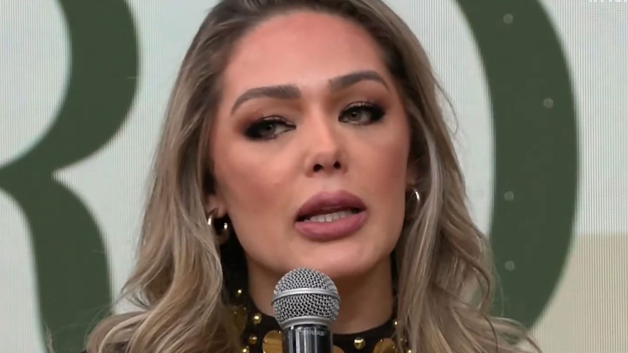 Tania Mara segurando microfone durante participação no programa Melhor da Tarde da Band