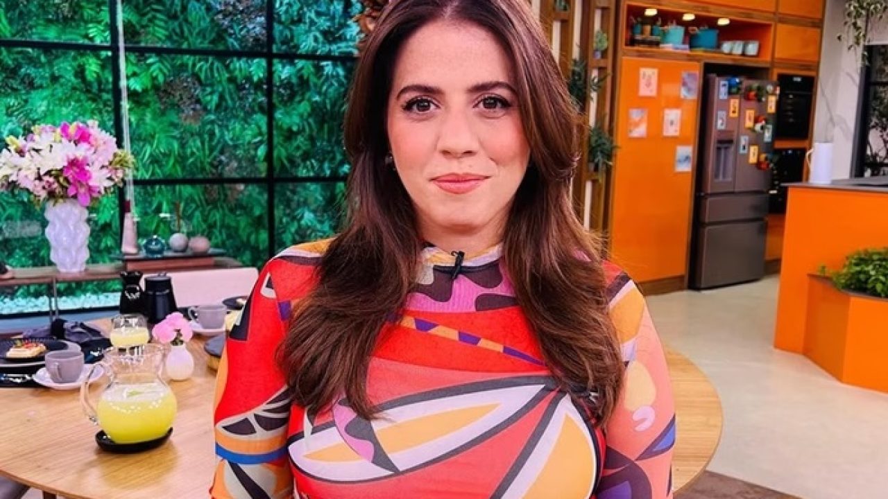 Tati Machado no estúdio do Mais Você, com cenário colorido e cozinha ao fundo