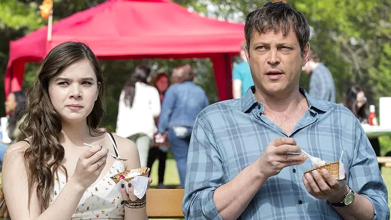 Jovem e homem comem sorvete durante evento ao ar livre em cena do filme