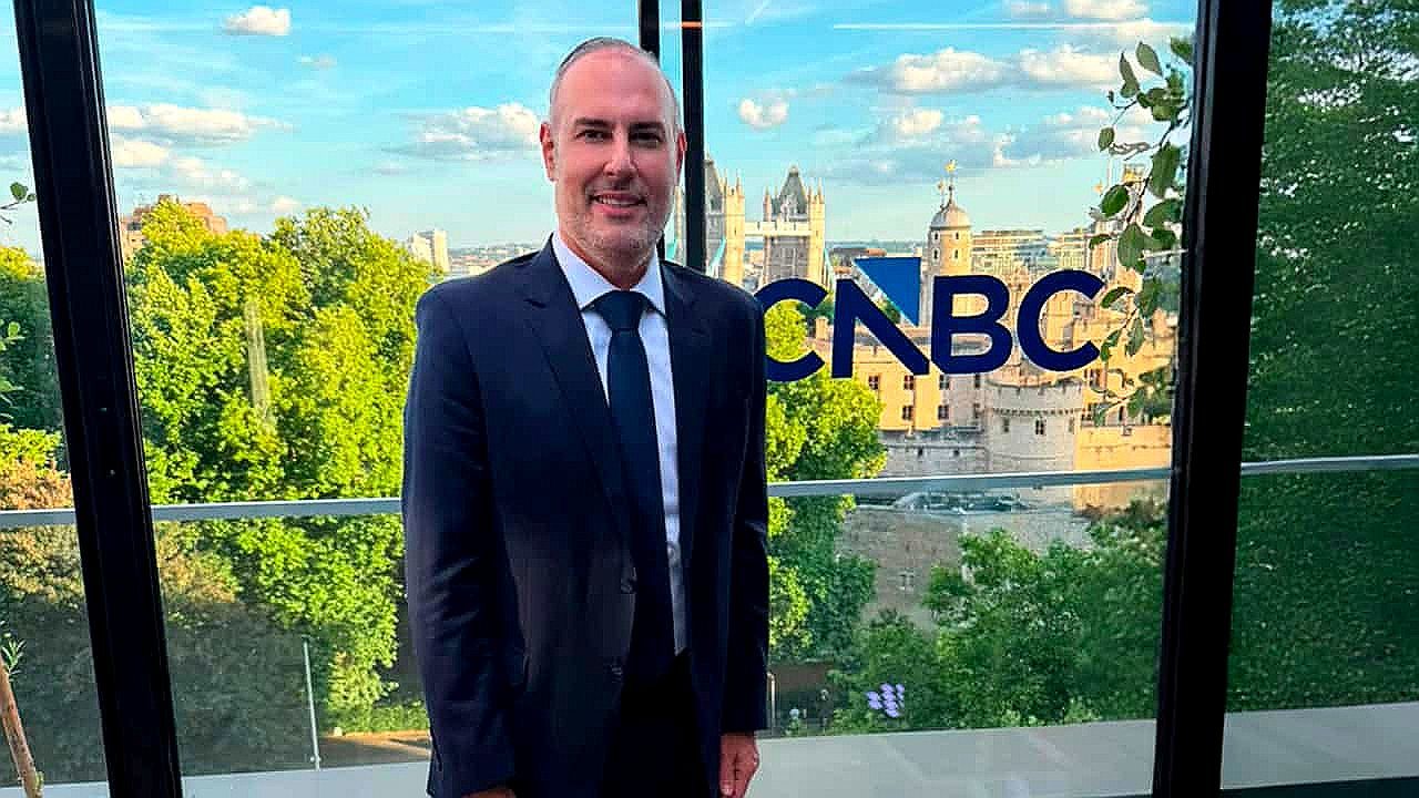 Douglas Tavolaro posa diante do logotipo da CNBC com a Tower Bridge de Londres ao fundo