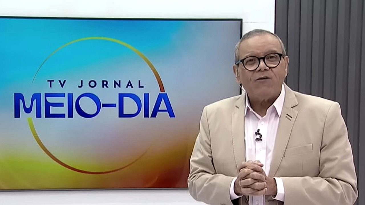 Homem de óculos apresenta o TV Jornal Meio-Dia em estúdio de telejornal local