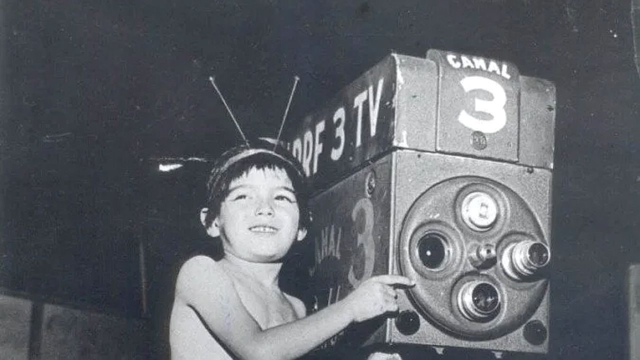 Criança posa ao lado de câmera da TV Tupi com identificação do Canal 3 em foto histórica