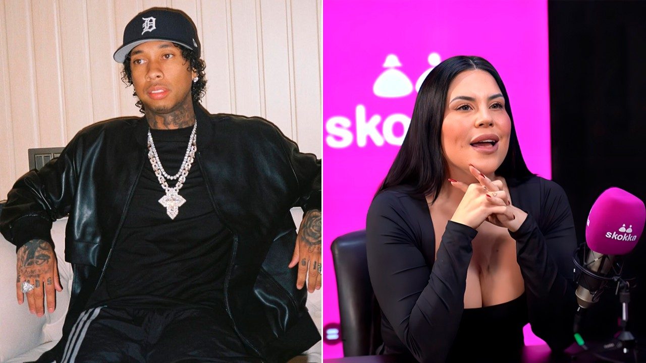 Tyga de boné e jaqueta preta posa sentado ao lado de Jéssica Amaral durante entrevista em estúdio
