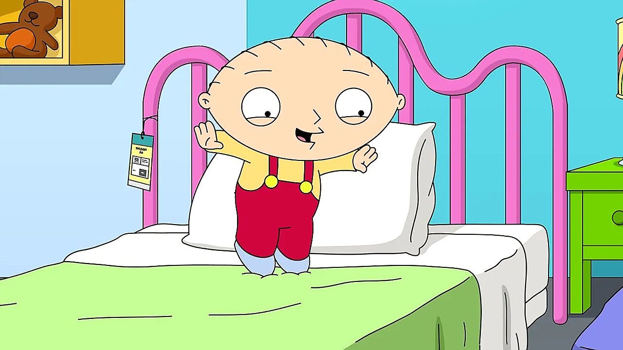 Personagem animado com cabeça grande e olhos arredondados está em pé sobre uma cama com estrutura rosa, em um quarto colorido, usando jardineira vermelha e camiseta amarela.