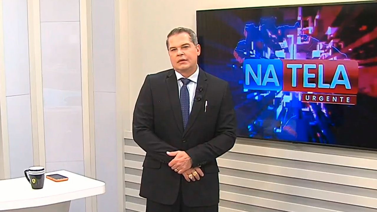 Vicente Datena no estúdio do programa Na Tela Urgente em frente a tela com o logotipo da atração
