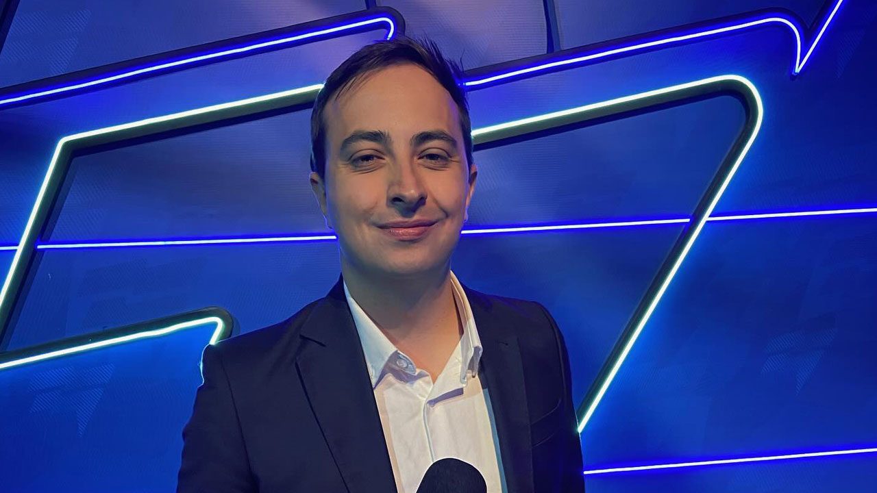 Victor La Regina posa diante de painel azul iluminado por luzes de LED em ambiente interno