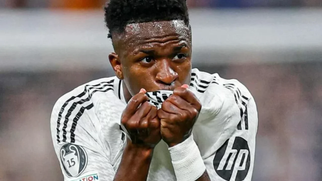 Vini Jr comemora gol beijando o escudo do Real Madrid durante partida da Liga dos Campeões