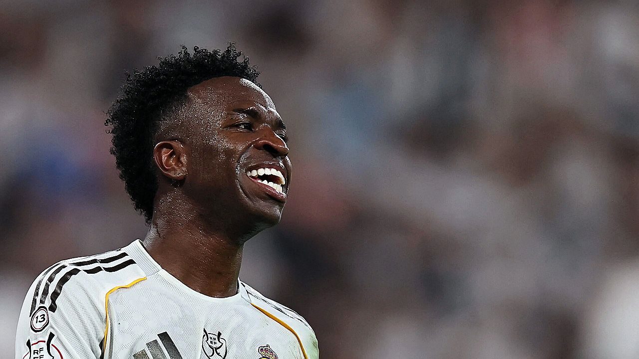 Vinícius Júnior sorri durante partida do Real Madrid em campo lotado no estádio