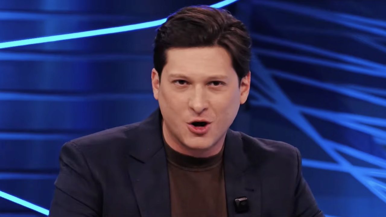 Willian Kury fala durante estreia do RedeTV! Notícias em estúdio com iluminação azul ao fundo